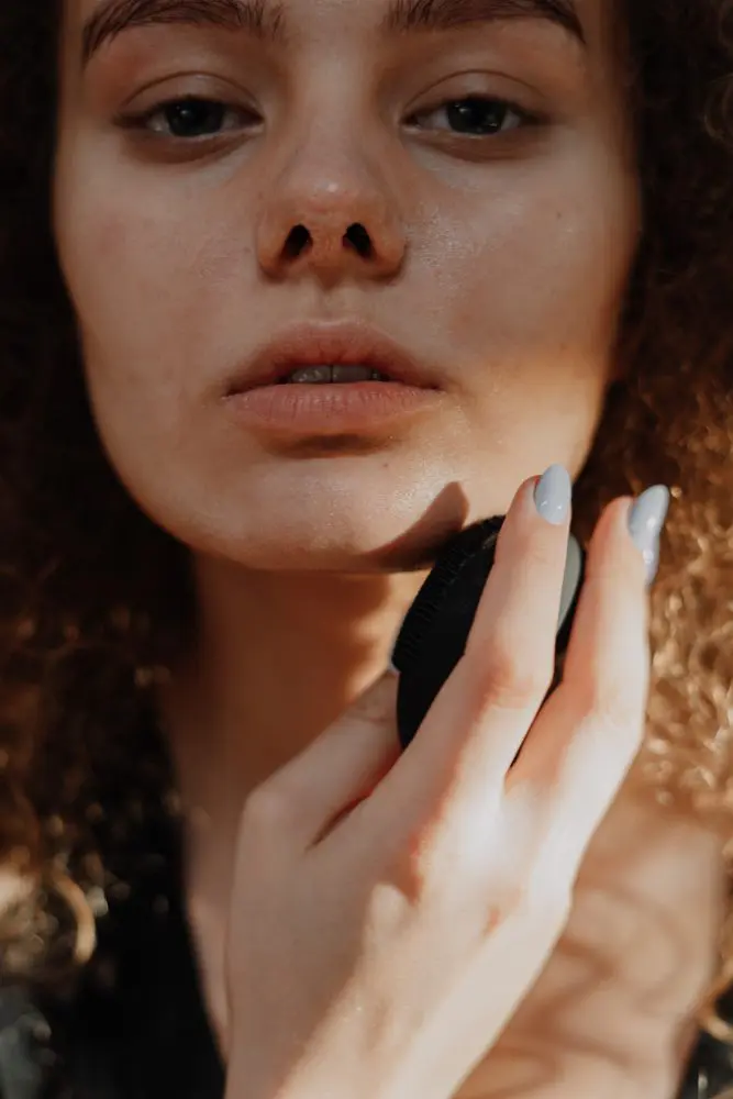 Woman with brown hair holding her face